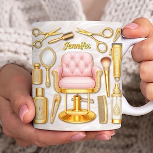 Könnte beinhalten: Weiße Keramik-Tasse mit einem Design, das einen rosa Friseurstuhl, goldfarbene Schönheitswerkzeuge und den Namen "Jennifer" in goldener Schrift zeigt. Das Design umfasst Scheren, einen Kamm und einen Handspiegel.