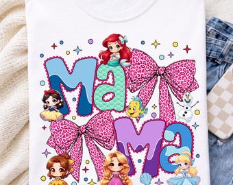 以下が含まれることがあります： 白のTシャツに「Mama」の文字が青と紫で描かれ、ピンクのリボンと漫画のプリンセスが飾られています。デザインにはアリエル、白雪姫、ベル、シンデレラが含まれ、星と円が描かれています。