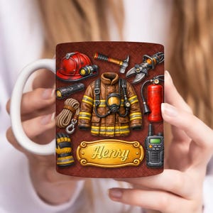 May include: White ceramic mug featuring a firefighter theme. The design includes a red helmet, brown jacket, and various tools like a flashlight, rope, and fire extinguisher. A gold nameplate reads "Henry".