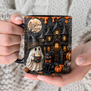 Może przedstawiać: Czarny ceramiczny kubek ze szczegółową sceną halloweenową przedstawiającą ducha trzymającego kubek w gwiazdki, czarnego kota w pomarańczowej muszce oraz ciemną posiadłość z oświetlonymi oknami. Napis Emily's House znajduje się w pobliżu pełnego księżyca.