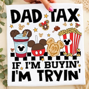 May include: White t-shirt featuring the words "DAD TAX" and "IF I'M BUYIN' I'M TRYIN'". The design includes cartoon images of Mickey Mouse-themed treats such as a drink, candy apple, waffle, popcorn, and donuts.