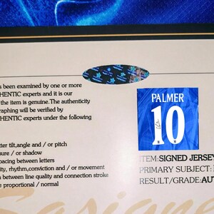 May include: A certificate of authenticity with the text "PALMER 10" on a blue patch, indicating a signed jersey. The certificate is framed with a black border and includes details about the item's verification process.