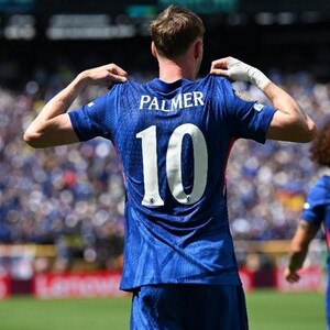 May include: A blue soccer jersey with the name "PALMER" and the number "10" in white. The jersey has a small emblem on the lower left. The person is holding the jersey by the shoulders.