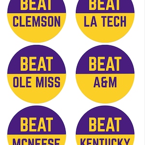May include: Six circular stickers with a purple and gold color scheme. Each sticker has the word "BEAT" in bold, purple letters above a team name in gold. The teams listed are Clemson, LA Tech, Ole Miss, A&M, McNeese, and Kentucky.