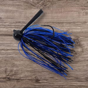 May include: A black and blue fishing jig with a black hook and a black head. The jig features blue and black rubber strands. The fishing lure is designed for catching fish.