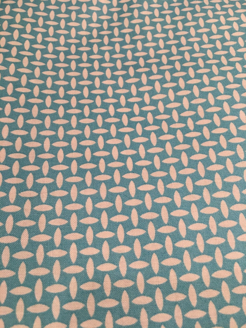 Puede incluir: Tela turquesa con un patr&oacute;n tejido blanco de &oacute;valos superpuestos.