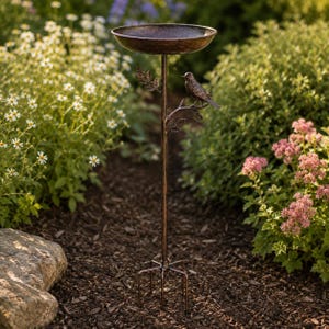 Peut inclure: Un bain d'oiseaux en métal de couleur bronze doté d'un bassin circulaire peu profond sur un pied fin. Le pied est orné d'un petit oiseau en métal perché sur une branche et de plusieurs feuilles. La base se compose de quatre tiges métalliques.