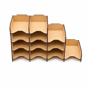 Può includere: Un organizer in legno non rifinito a più scomparti. Presenta un design a gradini, con ogni livello contenente spazi di stoccaggio aperti. Il legno è di colore marrone chiaro naturale e la costruzione sembra essere tagliata al laser.