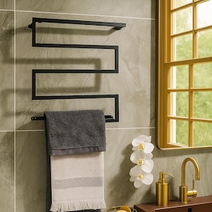 Peut inclure: Intérieur de salle de bain moderne avec un porte-serviettes noir et deux serviettes, un miroir doré et un lavabo marron avec des robinets dorés. Les serviettes sont grises et beiges. Un porte-savon doré et des orchidées blanches complètent le décor.