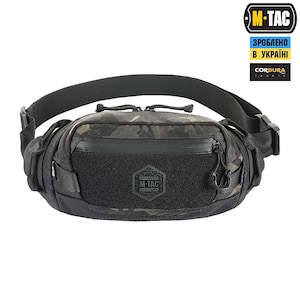 May include: Black tactical waist pack with a camouflage pattern and the M-TAC logo. The pack features a zippered main compartment, adjustable strap, and multiple pockets. The text "CORDURA FABRIC" is visible.
