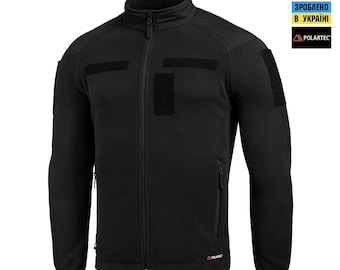 May include: Black fleece jacket with a full-length zipper and a stand-up collar. The jacket features multiple Velcro patches and a small zippered pocket on the chest. The Polartec logo is visible on the lower right side.