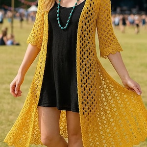Può includere: Un cardigan lungo all'uncinetto giallo senape con trama aperta. Il cardigan ha maniche a tre quarti e un bordo smerlato. Indossato sopra un vestito nero, il cardigan è abbinato a una collana di perline turchesi. Lo sfondo mostra un campo erboso e figure sfocate.