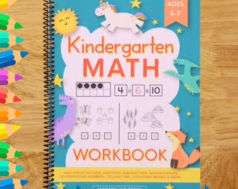 May include: A spiral-bound kindergarten maths workbook with a blue cover. The cover features the text "Kindergarten MATH WORKBOOK" with illustrations of a unicorn, sun, dinosaur, fox, and stars. The workbook is for ages 5-7.