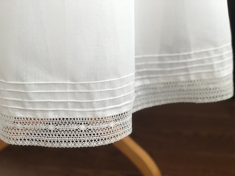May include: White cotton skirt with a lace trim and three rows of stitching around the hem.