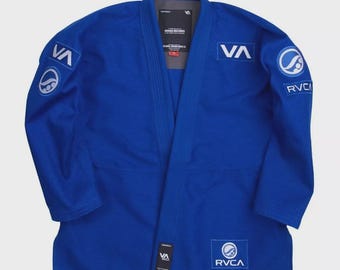 May include: A vibrant blue martial arts uniform, featuring the "VA" logo on the sleeves and chest. The uniform has a V-neck design and includes the "RVCA" logo. The jacket is made of a durable fabric, suitable for training and competition.