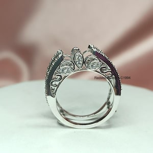 Puede incluir: Un engaste de anillo de plata con un delicado dise&ntilde;o floral y peque&ntilde;as piedras transparentes. El engaste est&aacute; abierto en el centro para sujetar una piedra central m&aacute;s grande.