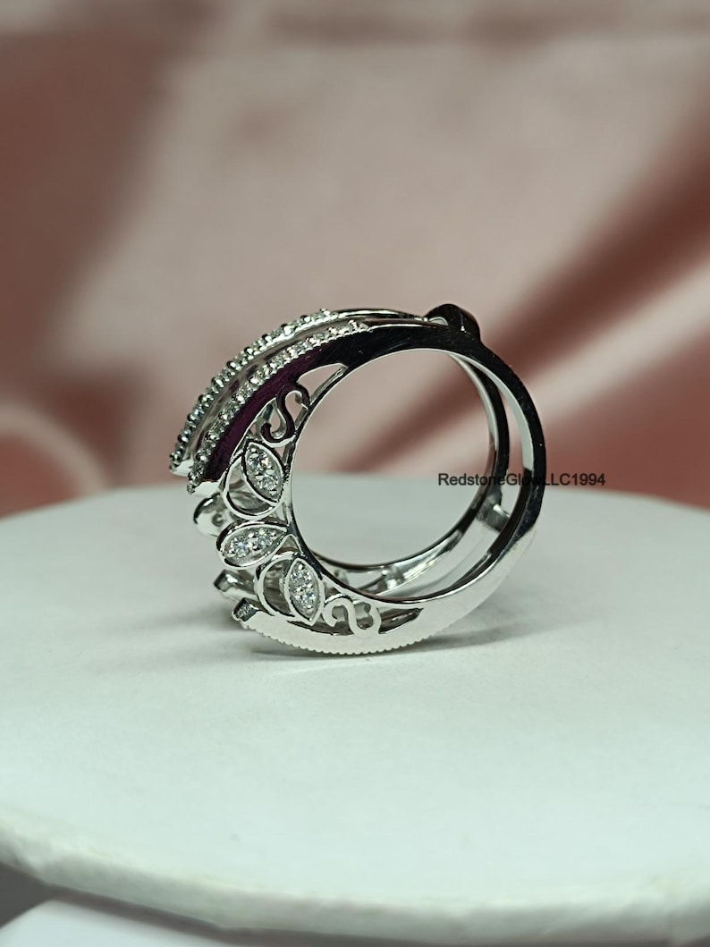 Puede incluir: Un anillo de plata con un dise&ntilde;o delicado e intrincado que presenta peque&ntilde;as piedras transparentes. El anillo tiene un dise&ntilde;o curvo y calado con un motivo floral.