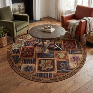 May include: A round area rug with a floral and leaf pattern in shades of brown, red, and green. The rug features a border with a repeating design and is placed on a hardwood floor. A dark wooden table sits on top of the rug.