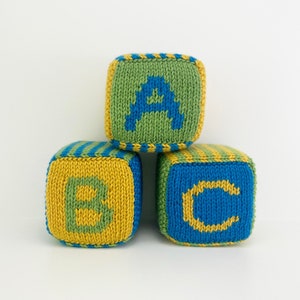 set of knit blocks with letters a, b and c in green, yellow and blue