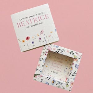 Könnte beinhalten: Ein quadratisches Einladungs- und Box-Set mit floralen Designs und Text. Die Einladung lautet "LA PRIMA COMUNIONE DI BEATRICE 6 SETTEMBRE 2026". Die Box hat ein Blumenmuster und den Text "I ricordi più belli fioriscono accanto a chi amiamo GRAZIE".
