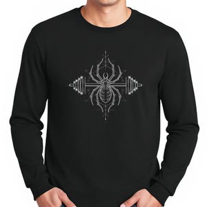 May include: Black long-sleeve shirt featuring a white graphic of a spider centered between two barbell weights. The spider and weights are detailed with fine lines, creating a geometric design. The shirt is made of a soft material.