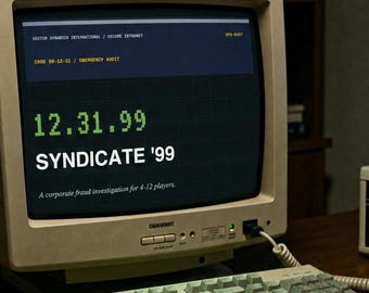 May include: A beige vintage computer monitor displaying the text 12.31.99 SYNDICATE '99, a matching keyboard, a gray landline telephone, a digital clock showing 23:57:41, a black floppy disk, a red pen, and printed documents on a wooden desk.