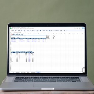 May include: A laptop displaying a spreadsheet titled "IFTA FUEL TAX LOG" on a wooden stool against a green background. The spreadsheet contains data in columns and rows, with headings like "Date," "Location," and "Gallons."