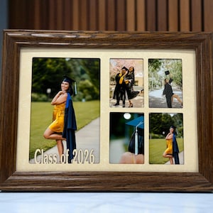 May include: A multi-photo wooden picture frame with five openings. The frame holds graduation photos, including a person in a yellow dress and graduation cap. The text "Class of 2026" is visible on the frame.