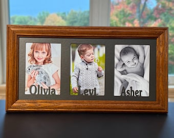 May include: A wooden triple photo frame with three individual openings. Each opening contains a black and white photograph of a child. The names "Olivia", "Levi", and "Asher" are displayed below each photo in a cutout font.