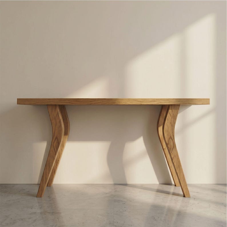 Op de afbeelding: Een lichtbruine houten consoletafel met een rechthoekig blad en gebogen poten. De tafel is gemaakt van lichtgekleurd hout en heeft een modern design. De gebogen poten geven een unieke uitstraling. De tafel is ongeveer 152 cm lang.