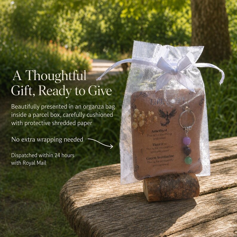 May include: A gift set in an organza bag, ready to give. The set includes a keychain with purple, black, and green beads, and a card with text. The gift is presented on a wooden surface, with a natural outdoor background.