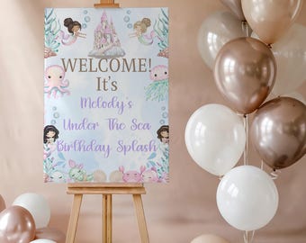 May include: A welcome sign for a birthday party with a mermaid theme. The sign is on an easel and says "Welcome! It's Melody's Under The Sea Birthday Splash". There are balloons in shades of brown and white in the background.