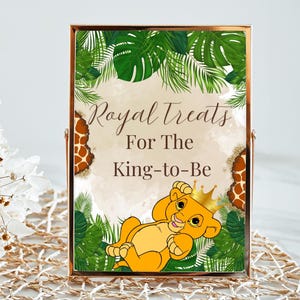 Könnte beinhalten: Ein druckbares Schild mit Dschungel-Motiv, auf dem ein Cartoon-Löwenjunges mit einer Krone zu sehen ist. Das Schild lautet "Royal Treats For The King-to-Be".