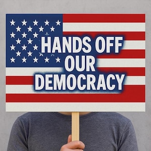 May include: A person holding a sign with an American flag design. The sign says "Hands Off Our Democracy".