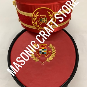 May include: Red Masonic hat and case. The hat is cylindrical with gold trim and a gold embroidered emblem. The case is round, red, and has a black zipper. The text "MASONIC CRAFT STORE" is printed on the image.