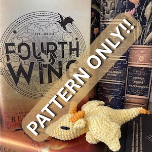 May include: A crocheted yellow dragon figurine with orange accents rests on a stack of books. The book in the foreground is titled "Fourth Wing" with the text "Fly...or Die." A banner across the image reads "Pattern Only!!"