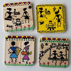 May include: Set of four square wooden coasters with hand-painted Warli art. Each coaster features a unique scene with stick figures in black, accented with colors like yellow, blue, and red. The coasters are designed for use with drinks.