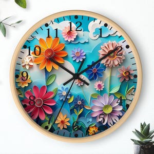 Könnte beinhalten: Eine runde Wanduhr mit hellem Holzrahmen. Das Zifferblatt zeigt ein lebendiges Blumendesign mit bunten Papierblumen vor einem blauen Himmel. Schwarze Zeiger zeigen die Uhrzeit an.