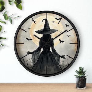 May include: Black round wall clock featuring a witch silhouette with a large hat, arms outstretched, and a full moon backdrop. Bats are scattered around the clock face. The clock has black hands and a black frame, perfect for Halloween decor.