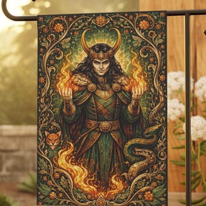 Puede incluir: Una bandera de jardín decorativa con una ilustración detallada de una figura con cuernos dorados, sosteniendo llamas. El diseño incluye una combinación de colores verde y dorado con motivos florales y de serpientes, creando un tema de fantasía.