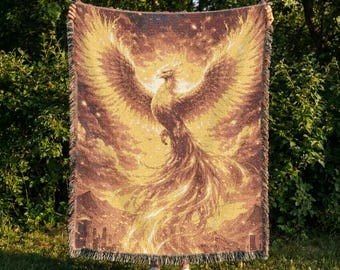 Manta tejida con el diseño del Fénix de Fuego, tapiz dorado con el diseño del ave mítica.