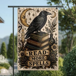 May include: A garden flag with a black raven on a stack of books, with the titles "Witches Lore", "Potions", and "Curses". The flag has a crescent moon, stars, and the text "READ MORE SPELLS".