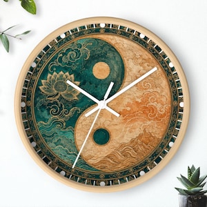 Pode incluir: Relógio de parede redondo com moldura de madeira. O mostrador do relógio apresenta um design Yin e Yang em verde-azulado, dourado e bege, com ponteiros brancos. O design inclui motivos de flor de lótus e nuvens.