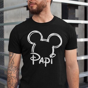 Może przedstawiać: Czarny T-shirt z białym konturem uszu Myszki Miki i napisem "Papi" pod spodem.