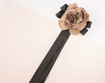 Jasny brązowy kwiat broszka z czarną kokardką z wstążki, muszka Broszka kwiat