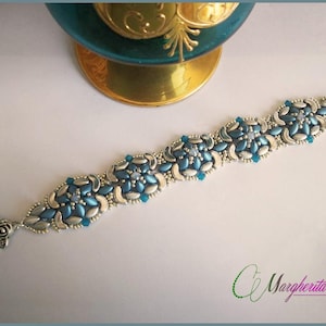 May include: A silver and blue beaded bracelet with a toggle clasp. The bracelet features a repeating pattern of silver and blue beads.