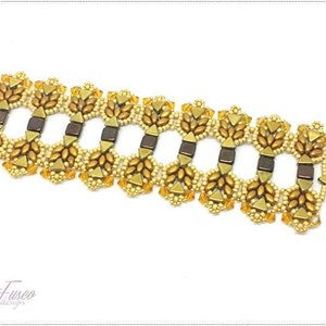 Può includere: Un braccialetto di perline dorate e marroni con una chiusura in metallo decorativa. Il braccialetto presenta un motivo ripetitivo di foglie e forme geometriche.