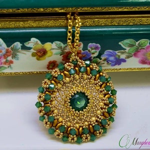 Può includere: Una collana con un ciondolo rotondo di perline dorate e verdi. Il ciondolo presenta una pietra preziosa verde centrale circondata da perline verdi e dorate più piccole.
