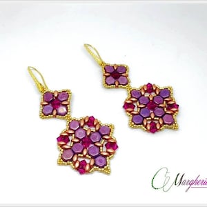Peut inclure: Une paire de boucles d'oreilles en or avec un motif géométrique composé de perles violettes et roses. Les boucles d'oreilles sont faites de petites perles facettées et ont un design suspendu.