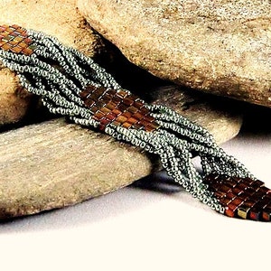 May include: A braided bracelet with silver and brown beads. The bracelet has a toggle clasp.